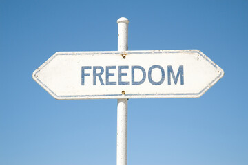 A signpost with the word "FREEDOM" points towards a life of liberation