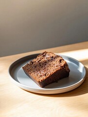 Slice of chocolate cake on a grey plate. the cake appears to be freshly baked and has a rich, dark brown color with visible chunks of chocolate throughout.