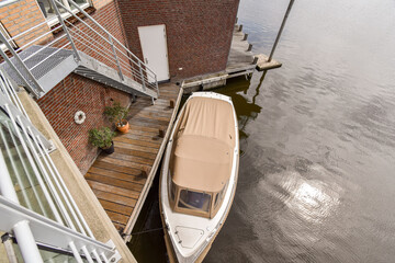 A contemporary home situated near a serene body of water, featuring a boat dock and elegant...