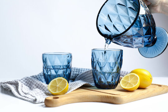 hand pouring water from jug into glass