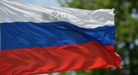 A Russian Flag billowing in the wind, showcasing its vibrant colors and intricate details against a blurred green background