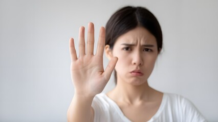Expressing discontent young woman's gesture indoor setting portrait photography neutral background emotional communication
