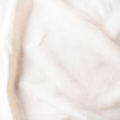 Natural white cotton linen fabric background. Soft plain textile top view surface earth tone color. Close-up texture of neutral white cloth for display products, mockups or presentations.