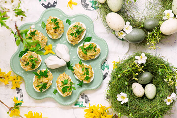 Easter deviled eggs with fried champignons on Easter background..top veiw