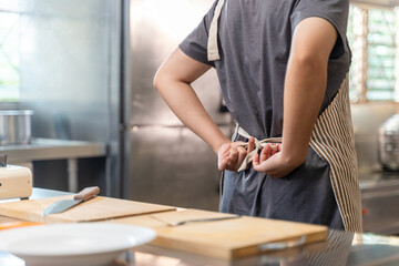 Chef Tying Apron in Professional Kitchen