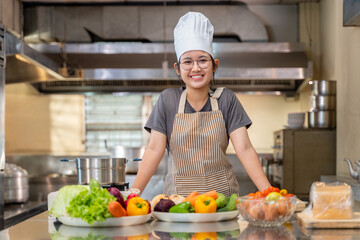 Smiling Female Chef in Kitchen with Fresh Vegetables on Counter