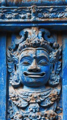 Intricate blue carved stone face detail, ancient temple facade.