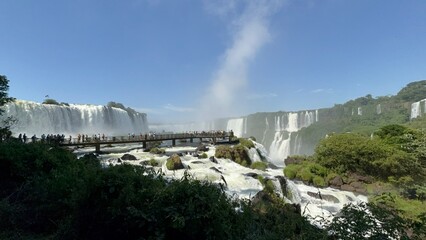 Rainbow over the waterfalls of Foz do Iguaçu with mist and lush forest in the background