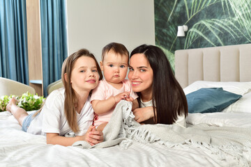 Mother and her daughters playing and smiling. Happy family.Home interior.
