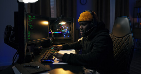 A young programmer begins his night shift at a remote job, entering a dark room lit by blue LED...