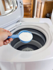 Measuring Scoop with Clean Detergent Near Modern Washing Machine