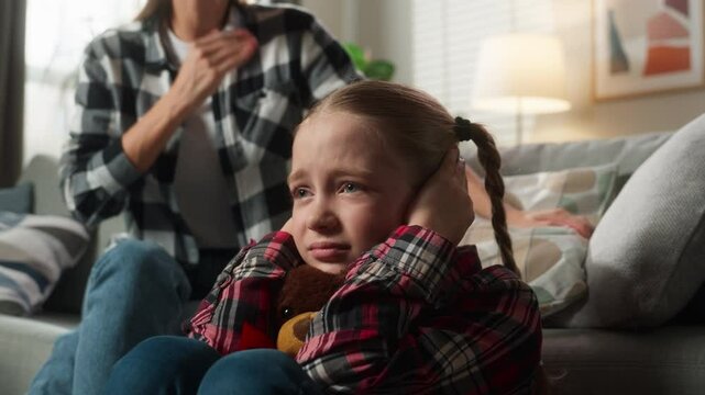 Family domestic violence trouble frustrated little child girl kid daughter close ears with hands at home with angry furious mother woman babysitter scold talking argument conflict psychology problem