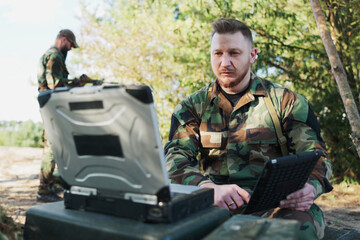 In the field, the army commander engages in a video call with the head of the army base, providing...