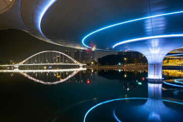 The reflection of a luminous pedestrian bridge in the water, Chengdu, China