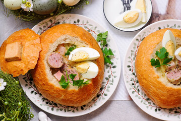 Traditional Polish Easter soup zurek served in a loaf of bread, smoked meats and egg..top veiw