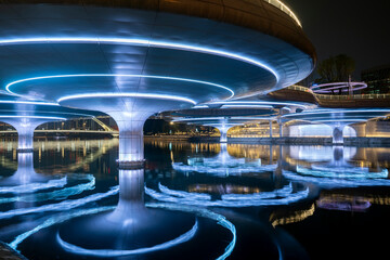 The reflection of a luminous pedestrian bridge in the water, Chengdu, China