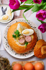 Traditional Polish Easter soup zurek served in a loaf of bread, smoked meats and egg..top veiw