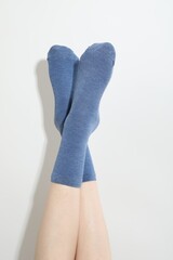 Woman in blue socks on light background, closeup