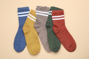 Many different pairs of socks on beige background, flat lay