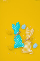 Handmade Easter concept. Sewn textile bunnies with traditional decoration. Festive symbols