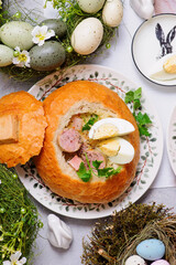 Traditional Polish Easter soup zurek served in a loaf of bread, smoked meats and egg..top veiw
