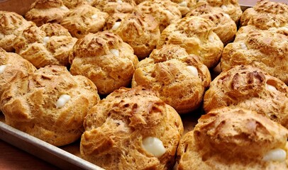 Light, airy cream puffs filled with luscious vanilla custard, dusted with powdered sugar. A delightful treat that melts in your mouth with each bite, perfect for any occasion.