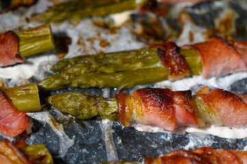 Deliciously wrapped asparagus spears roasted to perfection with crispy bacon on a warm baking tray