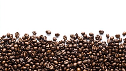 Obraz premium Roasted coffee beans scattered on a white background.