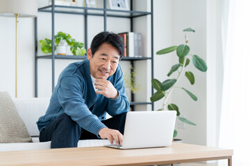 リビングでパソコンを使うミドルの男性