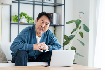 リビングでパソコンを使うミドルの男性