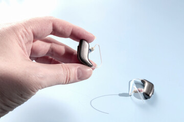 Female hand holding modern hearing aid