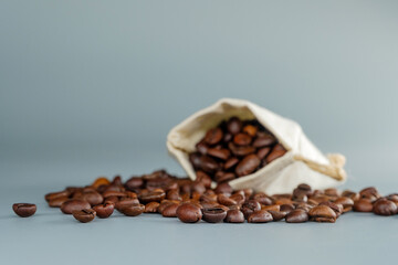 Coffee Beans and a Burlap Sack. Focus on coffee beans spilling from a sack, with a soft, blurred background for depth.