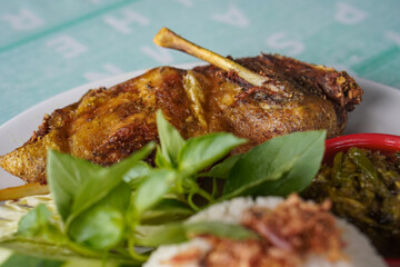 Indonesian fried duck, captured on April 16, 2025. Crispy on the outside and tender inside, served with rice, sambal, and fresh vegetables for a rich, savory meal