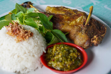 Indonesian fried duck, captured on April 16, 2025. Crispy on the outside and tender inside, served with rice, sambal, and fresh vegetables for a rich, savory meal