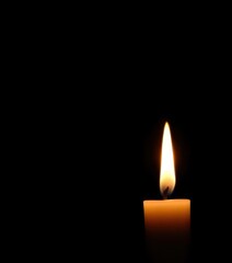 Single lit candle flame against pure black background, glow, object, spiritual