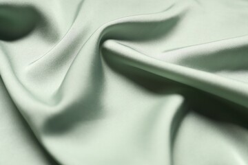 Light green crumpled silk fabric as background, top view