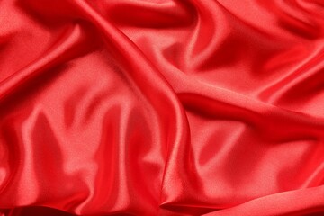 Red crumpled silk fabric as background, top view