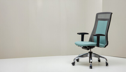 Everyday objects - for downstream advertisement and design: A modern teal and gray ergonomic office chair sits prominently on a white surface against a light gray wall.