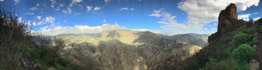 Naklejka premium Panoramic view of mountainous landscape with clear sky and lush greenery