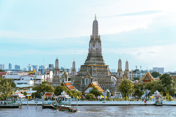 A scenic riverside view containing the beautiful temple in Bangkok, Wat Arun Ratchawararam Ratchawaramahawihan, which rises majestically from the Chao Phraya River