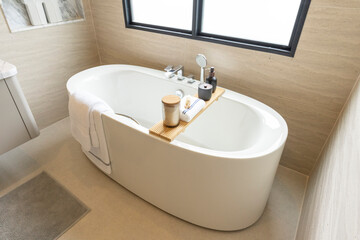 Bathroom interior, modern spacious white bathtub by the window.