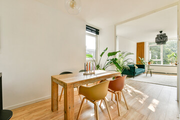 Stylish and modern interior featuring a wooden dining table, comfortable seating, and large windows...