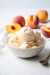 Peach ice cream in a white bowl on white marble table with fresh peaches, summer dessert idea