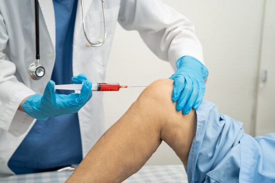 Asian doctor inject Hyaluronic acid platelet rich plasma into knee of senior woman.