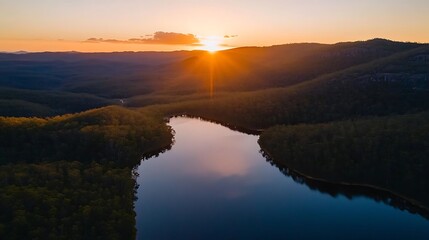 Fototapeta premium Serene sunset over a winding lake nestled in a valley.