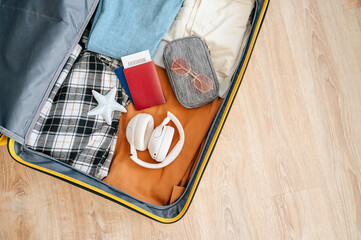 A suitcase packed with clothes, travel items and accessories representing preparation for a trip or...
