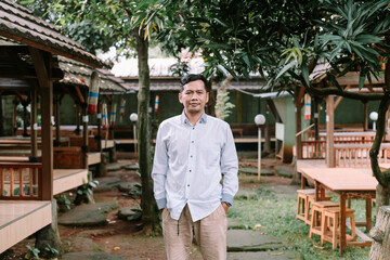 Man standing confidently in traditional indonesian restaurant ambience