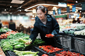 Woman Selecting Fresh Vegetables in Supermarket Produce Section