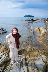 Muslim Asian Women Stand on the Stone of the Sea Tei with empty space for advertising
