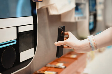 Capturing the Moment: A Hand Holding a Smartphone Near a Digital Display
